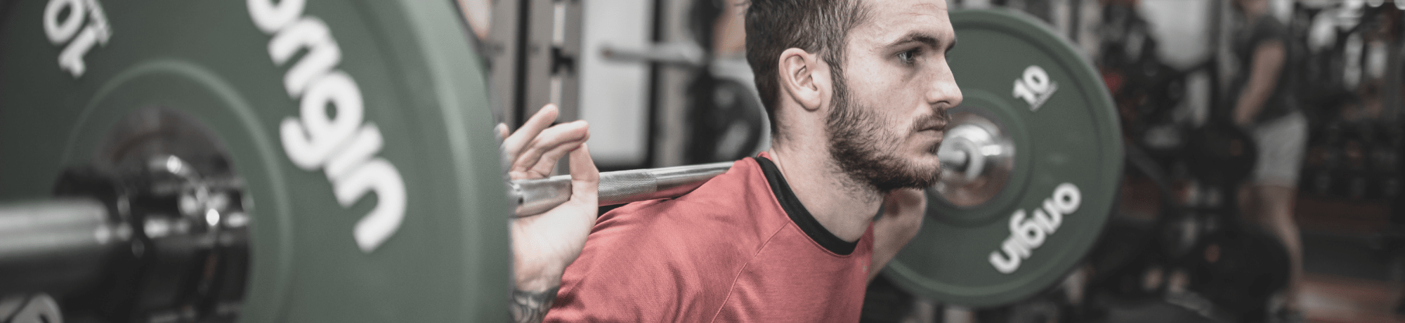 Man Squatting In Gym