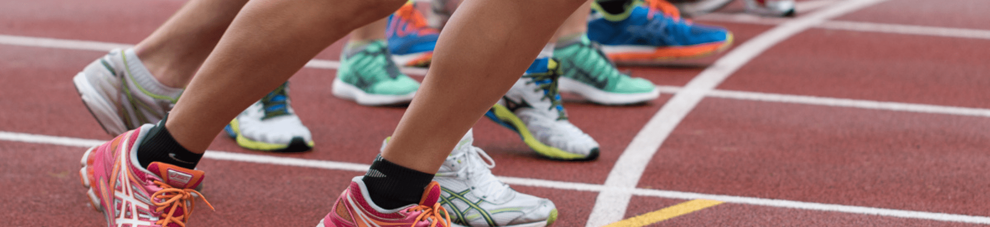 Runners Starting A Race On Athletics Track