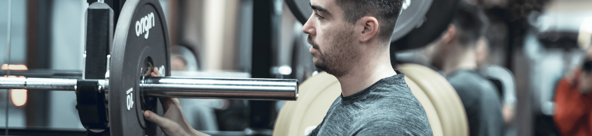 Man Loading Barbell With Weights